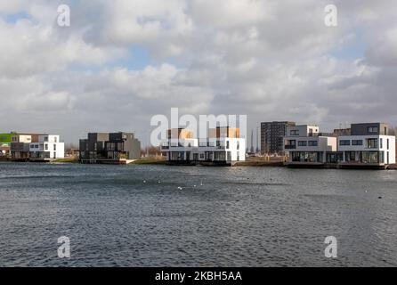 Case galleggianti ad Amsterdam visto il 17 febbraio 2020. I Paesi Bassi sono un paese protetto dalle dighe, dove le persone vivono su tumuli di origine umana che li innalzano sopra il livello del mare, e nell'acqua su case galleggianti. Le case galleggianti e gli hotel galleggianti possono essere visti lungo i canali di Amsterdam e di altre città. Le case galleggianti sono state suggerite come una soluzione vitale, ecofriendly e sostenibile alle necessità di alloggiamento dell'Olanda moderna. Un esempio di case galleggianti ad Amsterdam è lo Steigereiland, la prima isola costruita parte dell'arcipelago di IJburg, nella parte orientale della città. Quest'isola wa Foto Stock