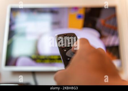Una persona che utilizza il telecomando di un televisore. Foto Stock