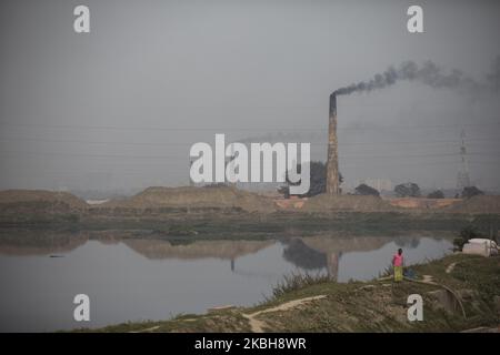 Il fumo esce dal forno a un campo di mattoni sulla periferia di Dhaka, Bangladesh, il 19 febbraio 2020. Il mondo sta attraversando una rapida urbanizzazione e il Bangladesh non fa eccezione. Un’urbanizzazione così rapida genera una domanda massiccia di mattoni in quanto è uno degli ingredienti chiave per costruire una struttura concreta. Per soddisfare questa crescente necessità, il numero di aree di produzione di mattoni è aumentato a un ritmo allarmante in Bangladesh. La maggior parte di essi si è svolta in terreni agricoli che causano una riduzione della produzione agricola. Sappiamo che bruciare il carbone provoca un'enorme emissione di carbonio-di-ossido ( Foto Stock