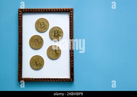 Bitcoins in una cornice su sfondo blu. Economia, finanza e tasso di cambio Foto Stock