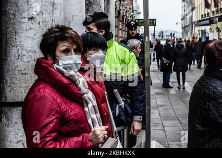 Persone che indossano maschere protettive a Venezia, Italia, il 23 febbraio 2020 per motivi di preoccupazione per l'infezione da coronavirus durante il 'volo' dell'aquila per il carnevale di Venezia. Più di 130 sono infettati da Coronavirus (Covid-19) in Italia. Le autorità di alcune città lombarde e venete hanno chiuso scuole, aziende e ristoranti, annullando eventi sportivi e servizi religiosi. (Foto di Manuel Romano/NurPhoto) Foto Stock