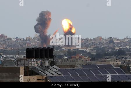 Una palla di fuoco e fumo sorge sopra gli edifici durante gli attacchi aerei israeliani a Khan Yunis, nella striscia di Gaza meridionale il 24 febbraio 2020. (Foto di Abed Rahim Khatib/NurPhoto) Foto Stock