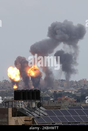 Una palla di fuoco e fumo sorge sopra gli edifici durante gli attacchi aerei israeliani a Khan Yunis, nella striscia di Gaza meridionale il 24 febbraio 2020. (Foto di Abed Rahim Khatib/NurPhoto) Foto Stock