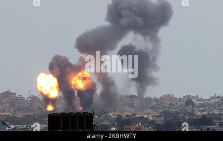 Una palla di fuoco e fumo sorge sopra gli edifici durante gli attacchi aerei israeliani a Khan Yunis, nella striscia di Gaza meridionale il 24 febbraio 2020. (Foto di Abed Rahim Khatib/NurPhoto) Foto Stock