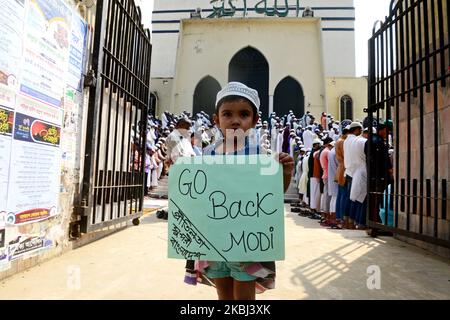 Un bambino del Bangladesh tiene un ply card con la madre per protestare contro la violenza comune a Nuova Delhi, in India, in dalla Moschea Nazionale di Baitul Mukarram durante la preghiera del venerdì a Dhaka, in Bangladesh, il 28 febbraio 2020. Almeno 24 persone sono state uccise negli scontri scoppiati tra sostenitori e oppositori del controverso Citizenship Amendment Act (CAA) di Nuova Delhi. La legge, approvata il 10 dicembre 2019, concede un percorso di cittadinanza indiana ai rifugiati di comunità indù, jain, buddiste, sikh, parsi o cristiane in fuga dall'Afghanistan, dal Bangladesh e dal Pakistan; Foto Stock