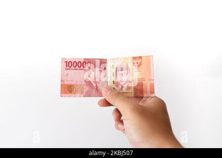 Semarang, Indonesia - 4 novembre 2022: Una mano tiene un denaro di Rupiah 100.000. Foto Stock