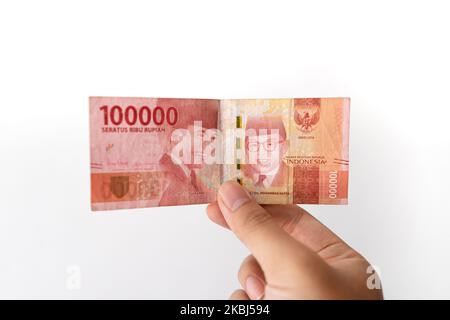 Semarang, Indonesia - 4 novembre 2022: Una mano tiene un denaro di Rupiah 100.000. Foto Stock