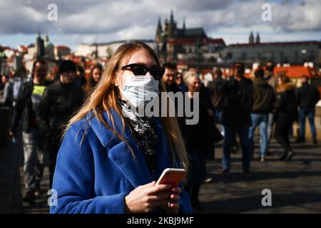 Una donna indossa maschere mentre visita il Ponte Carlo a Praga, Repubblica Ceca, il 1st marzo 2020. Oggi, la Repubblica Ceca ha confermato i suoi primi tre casi di coronavirus, con tutti i pazienti che hanno viaggiato dall'Italia settentrionale. Due pazienti che mostravano sintomi lievi erano a Praga e il terzo nella città di Usti nad Labem, a 90 km a nord della capitale. (Foto di Beata Zawrzel/NurPhoto) Foto Stock