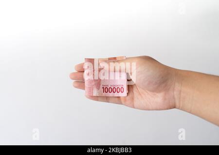 Semarang, Indonesia - 4 novembre 2022: Una mano tiene un denaro di Rupiah 100.000. Foto Stock