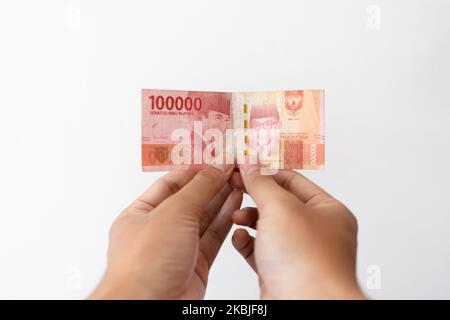 Semarang, Indonesia - 4 novembre 2022: Una mano tiene un denaro di Rupiah 100.000. Foto Stock