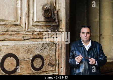 Adeeb Jawad Joudeh al Husseini, musulmano che è il portachiavi della chiesa, tiene la chiave di ferro 20cm, durante le celebrazioni del sabato pomeriggio all'ingresso della Chiesa del Santo Sepolcro nella Città Vecchia di Gerusalemme. Questa chiave è l’unica in grado di sbloccare le imponenti porte in legno della chiesa, un dovere che, secondo al Husseini, fu dato alla sua famiglia da Saladin, il sultano che catturò Gerusalemme dai crociati nel 1187 – una delle tante volte che controleva Gerusalemme, Ambita per la sua santità da parte di ebrei, cristiani e musulmani, ha cambiato le mani. Sabato 7 marzo 2020 a Jerusale Foto Stock