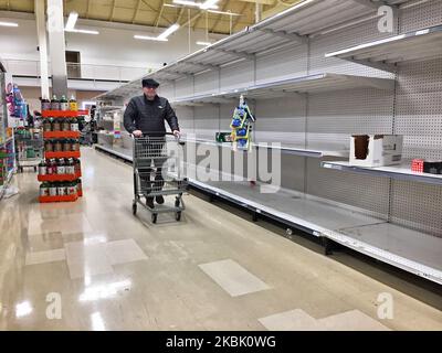 L'uomo passa davanti agli scaffali vuoti in un negozio di alimentari il 13 marzo 2020 a Toronto, Ontario, Canada. I negozi di alimentari erano pieni di grandi folle e lunghe code, come l'ultimo picco di nuovi casi di coronavirus (COVID-19) ha spinto il panico di acquisto in tutto il paese. I canadesi si sono precipitati nei negozi di alimentari e nei mercati per accatastare forniture come carta igienica e conserve. In molti depositi durante la sera le linee non soltanto hanno bloccato la gente dalla navigazione del deposito, ma inoltre completamente hanno avvolto intorno ai corridoi mentre i carrelli sovraccarichi di shopping hanno soffocato ogni pollice di spazio dei depositi. L'Organizzazione Mondiale della Sanità h Foto Stock