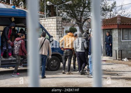 Agenti di polizia greci e forze di polizia di frontiera, scaricano i richiedenti asilo ammanettati dal furgone e li scortano alla stazione di polizia di Neo Chimonio. Il gruppo di 13 migranti e rifugiati maschi, la maggior parte provenienti dall'Afghanistan, attraversati illegalmente dalla Turchia alla Grecia, vicino al valico di frontiera di Kastanies, Evros e sono stati catturati, il 11 marzo 2020 (Foto di Nicolas Economou/NurPhoto) Foto Stock