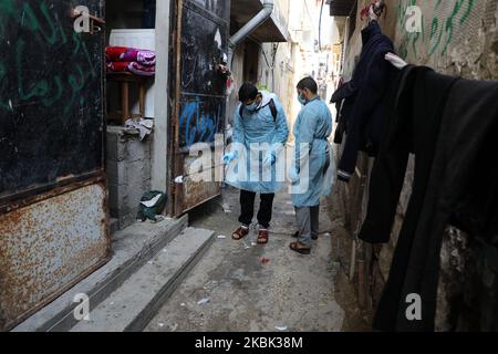 Volontari palestinesi spruzzano disinfettante in una strada nel campo profughi di al-Shati a Gaza City il 16 marzo 2020, durante una campagna di Hamas per arginare una nuova epidemia di coronavirus. – Il movimento islamico Hamas, che governa la striscia di Gaza assediata, ha compiuto l’insolito passo di chiudere i confini con Israele e Egitto come precauzione contro il virus. Finora non vi sono casi documentati di COVID-19 nell'enclave. (Foto di Majdi Fathi/NurPhoto) Foto Stock