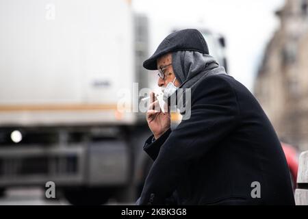 Un uomo che indossa una maschera facciale come misura preventiva fuma il 16 marzo 2020 a Parigi, Francia. La Francia attende stasera l'intervento del presidente Emmanuel Macron su un possibile confinamento, blocco, contenimento della popolazione francese contro la propagazione del Coronavirus (COVID-19). Questa mattina a Parigi le strade erano quasi vuote, il negozio era chiuso, come le galeries Lafayette, Cartier, sul viale Champs Elysees, e i ristoranti, come il ristorante Fouquet's. (Foto di Jerome Gilles/NurPhoto) Foto Stock