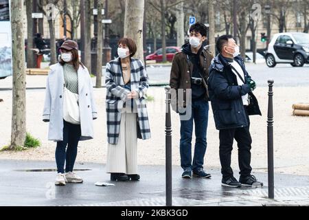 Turisti che indossano una maschera facciale come misura preventiva il 16 marzo 2020 a Parigi, Francia. La Francia attende stasera l'intervento del presidente Emmanuel Macron su un possibile confinamento, blocco, contenimento della popolazione francese contro la propagazione del Coronavirus (COVID-19). Questa mattina a Parigi le strade erano quasi vuote, il negozio era chiuso, come le galeries Lafayette, Cartier, sul viale Champs Elysees, e i ristoranti, come il ristorante Fouquet's. (Foto di Jerome Gilles/NurPhoto) Foto Stock