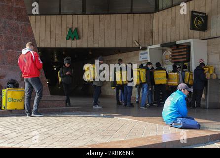 Glovo company delivery men stand in a line in front of McDonalds Express window in Kyiv, Ukraine on March 18, 2020. Authorities imposed a state of emergency in Kyiv city and Kyiv region due to the spread of coronavirus. (Photo by Sergii Kharchenko/NurPhoto) Stock Photo