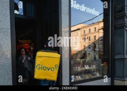 A Glovo delivery courier enters Biedronka shop in Krakow's center. Local food businesses adapt to a new reality of coronavirus by providing incresed delivery services to their customers. The Ministry of Health announced another 13 new cases of coronavirus in Poland, raising the total count to 251. On Wednesday, March 18, 2020, in Krakow, Poland. (Photo by Artur Widak/NurPhoto) Stock Photo