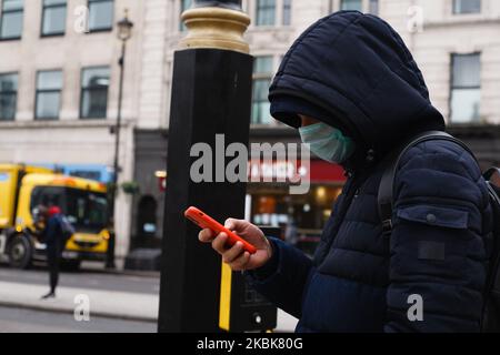 Un uomo indossa una maschera su una strada vicino deserta Cockspur Street, vicino a Trafalgar Square, a Londra, Inghilterra, il 19 marzo, 2020. In mezzo alla crisi del coronavirus del 19 in corso, il governo britannico oggi ha cercato di stronzare la crescente speculazione di un imminente blocco della città che implicava restrizioni alla circolazione. Si prevede tuttavia che tra breve saranno annunciate nuove misure per pub, caffè, bar e teatri. In precedenza, è stato annunciato che 40 stazioni della metropolitana di Londra devono essere chiuse mentre Transport for London inizia a ridurre i propri servizi, e molti spazi pubblici e le strade della capitale oggi erano visibili Foto Stock