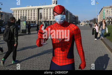 Una persona che indossa il costume di un uomo ragno con una maschera facciale usa e getta, propone un disinfettante per le mani ai passanti a Kyiv, Ucraina, 19 marzo 2020. 26 casi di COVID-19 sono stati confermati in laboratorio in Ucraina, 3 dei quali erano letali. (Foto di Sergii Kharchenko/NurPhoto) Foto Stock