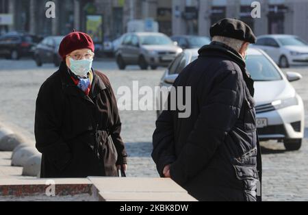 Elderly couple with a woman wearing washed away disposable face mask, walk in downtown Kyiv, Ukraine, March 19, 2020. 26 cases of COVID-19 were laboratory confirmed in Ukraine, 3 of them were lethal. (Photo by Sergii Kharchenko/NurPhoto) Stock Photo