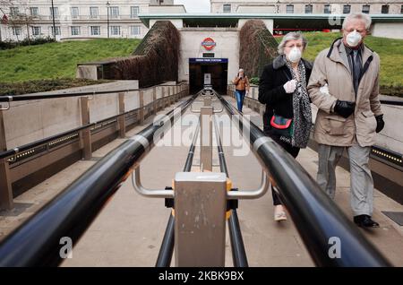 Una coppia anziana che indossa maschere facciali lascia la stazione della metropolitana Green Park a Londra, Inghilterra, il 20 marzo 2020. Nel Regno Unito è stato rivelato oggi che il gruppo consultivo scientifico per le emergenze (SAGE) del governo ha raccomandato di mantenere in vigore per la maggior parte dell'anno una qualche forma di "distensione sociale", con periodi alternati di restrizioni sempre più severe nel corso di quel periodo, per gestire la diffusione del coronavirus covid-19 e prevenire una schiacciante di ospedali. Le scuole stanno nel frattempo chiudendo oggi in tutto il paese fino a nuovo avviso, con eccezioni per i bambini vulnerabili Foto Stock