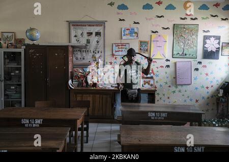 Un ufficiale indonesiano spruzza disinfettante in una scuola di Bali, un'isola di vacanza in Indonesia, il 21 marzo 2020. Il governo di Bali ha annunciato una serie di limitazioni per le celebrazioni intorno alla Giornata balinese del silenzio o Nyepi il 25 marzo, come i limiti posti sul numero di partecipanti, la posizione e la durata di diverse cerimonie e le parate tradizionali per prevenire la diffusione del coronavirus. (Foto di Agos Rudianto/NurPhoto) Foto Stock