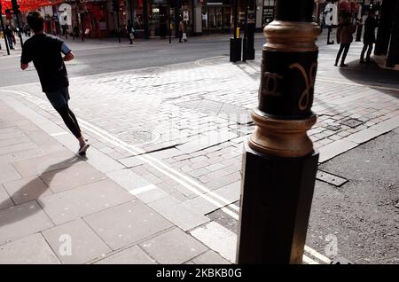 Un uomo scherza su una Shaftesbury Avenue quasi deserta a Londra, Inghilterra, il 21 marzo 2020. Gran parte del centro di Londra era praticamente vuota oggi, un giorno dopo che il primo ministro britannico Boris Johnson ordinò la chiusura di tutti i pub, bar, caffè e ristoranti del paese. L'iniziativa rappresenta un inasprimento delle misure volte ad applicare la "distanza sociale” che viene sollecitata ai cittadini a ridurre la crescita delle infezioni da coronavirus 19. Sono stati ordinati anche locali notturni, teatri, cinema, palestre e centri di svago chiusi. Alcuni negozi nel centro della capitale sono rimasti aperti oggi, anche se per lo più abbandonati Foto Stock