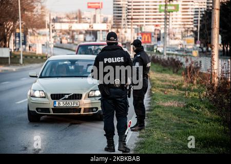 Agenti di polizia con maschere protettive, controllare i documenti dei passeggeri al check-point dell'uscita/ingresso nella città bulgara di Varna, Bulgaria, il 21 marzo 2020. Le misure preventive servono a fermare la diffusione del COVID-19 nel paese. Il governo bulgaro impone nuove misure restrittive e vieta ai cittadini di viaggiare in tutto il paese a meno che non debbano recarsi al lavoro o avere un'emergenza medica. Il Dipartimento della Salute ha confermato 163 casi di coronavirus in Bulgaria, con almeno tre decessi registrati. La misura dovrebbe terminare il 13 aprile, che è l'ultima data dello stato di emergenza Foto Stock