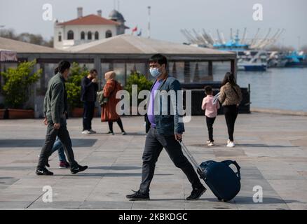 Persone con maschera protettiva cammina il 22 marzo 2020 a Istanbul, Turchia. A marzo 22, il numero di casi di coronavirus (COVID-19) ha raggiunto 1236, e ci sono 30 morti in Turchia, come confermato dal ministro della sanità. Le scuole e le università sono state chiuse dal marzo 16, e tutti gli eventi sportivi sono stati interrotti. L'istruzione online inizierà il 23 marzo. Ristoranti, caffè, negozi sono chiusi, e di solito strade affollate e quartieri sono vuoti a causa della quarantena. A Istanbul, Turchia, il 23 marzo 2020. (Foto di Erhan Demirtas/NurPhoto) Foto Stock