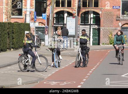 Due poliziotti durante la pattuglia parlano con una donna in strada vicino al Museumplein il 25 marzo 2020 ad Amsterdam, Paesi Bassi. Il ministro olandese della Giustizia e della sicurezza Ferdinand Grapperhaus ha ordinato nuove misure più severe per combattere la diffusione del coronavirus, nei parchi, nelle strade e negli spazi pubblici, le persone devono praticare l'allontanamento sociale e mantenere 1,5 metri, questo per un gruppo di tre o più persone (che non sono familiari) , verrà emessa una multa di 400 euro. (Foto di Paulo Amorim/NurPhoto) Foto Stock