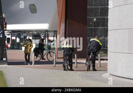 Two police officers patrols for people to practice social distancing and keep 1.5 meters near the Van Gogh Museum are close at the Museumplein on March 25, 2020 in Amsterdam,Netherlands. The Dutch Minister of Justice and Security Ferdinand Grapperhaushas ordered new stricter measures to combat the spread of coronavirus, in parks, streets and public spaces, people have to practice social distancing and keep 1.5 meters, this for a group of three people or more (who are not family) , a fine of 400 euros will be handed out. (Photo by Paulo Amorim/NurPhoto) Stock Photo