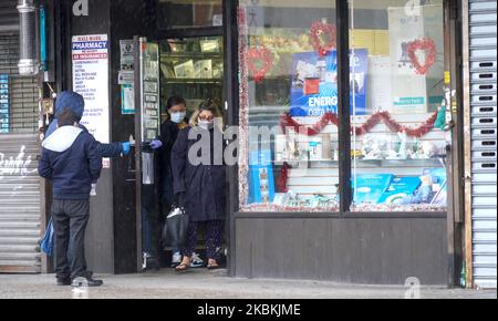 Le persone stanno aspettando il loro turno per entrare in farmacia a Queens, New York il 25th marzo 2020. (Foto di Selcuk Acar/NurPhoto) Foto Stock