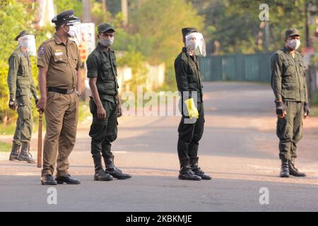 Sri Lanka militare personale indossare maschera viso stand guardia Atalugama, un villaggio circa 40 chilometri a sud della capitale di Colombo è stato bloccato dopo che un paziente confermato COVID-19 è stato trovato dopo essere venuto in contatto con almeno 26 persone, Mentre il coprifuoco nazionale continua ad essere in atto come precauzione contro la diffusione della malattia, a Colombo, Sri Lanka, il 28 marzo 2020. Dopo il blocco, due persone - un padre e una figlia - che erano venuti in contatto con il caso confermato, sono state ricoverate in ospedale dalle autorità per ulteriori esami. (Foto di Achila Jayawardana/NurPhoto) Foto Stock