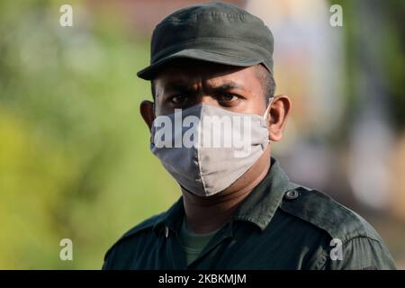 Sri Lanka militare personale indossare maschera viso stand guardia Atalugama, un villaggio circa 40 chilometri a sud della capitale di Colombo è stato bloccato dopo che un paziente confermato COVID-19 è stato trovato dopo essere venuto in contatto con almeno 26 persone, Mentre il coprifuoco nazionale continua ad essere in atto come precauzione contro la diffusione della malattia, a Colombo, Sri Lanka, il 28 marzo 2020. Dopo il blocco, due persone - un padre e una figlia - che erano venuti in contatto con il caso confermato, sono state ricoverate in ospedale dalle autorità per ulteriori esami. (Foto di Achila Jayawardana/NurPhoto) Foto Stock