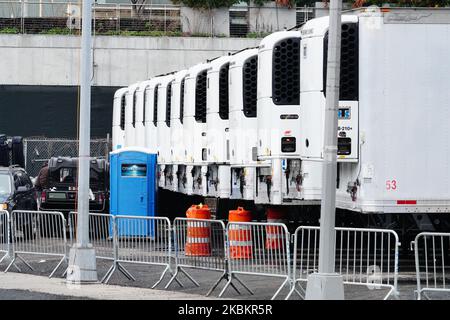 Una fila di unità di refrigerazione usate come morgue improvvisate sono viste parcheggiate dietro il Belleview Hospital Center, New York City, il 30 marzo 2020. (Foto di John Nacion/NurPhoto) Foto Stock