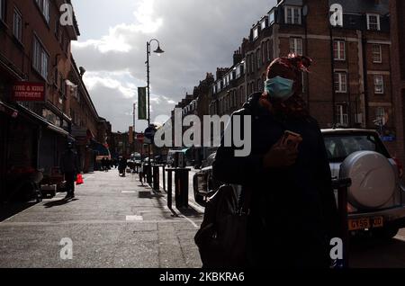 Una donna che indossa una maschera cammina lungo East Street nel quartiere di Southwark, che ha tra i più alti casi di coronavirus covid-19 in tutto il Regno Unito, a Londra, Inghilterra, il 30 marzo 2020. I dati ufficiali riferiscono che Southwark ha attualmente 368 casi di covid-19, il più alto a Londra e il quinto più alto nel Regno Unito nel suo complesso, dietro Sheffield (428), Glasgow (449), Hampshire (498) e Birmingham (578). Anche il vicino quartiere londinese di Lambeth è colpito duramente, con 366 casi, sesto più alto nel Regno Unito. La Gran Bretagna intanto ha iniziato la sua seconda settimana di blocco oggi, con le misure s Foto Stock