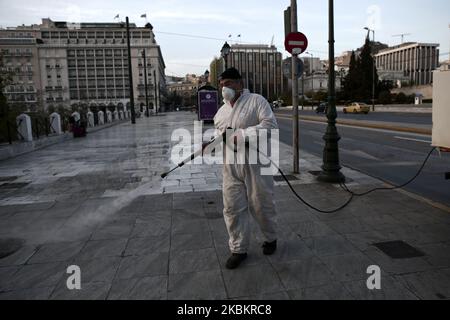 Un lavoratore del comune di Atene che indossa una tuta di protezione disinfetta la zona di piazza Syntagma, nel centro di Atene, in Grecia, il 30 marzo 2020. Secondo il Ministero della Salute il bilancio delle vittime di Covid-19 in Grecia è salito a 43 (Foto di Panayotis Tzamaros/NurPhoto) Foto Stock