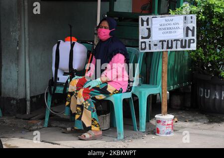 Controlli più stringenti agli ingressi residenziali, i residenti effettuano il check-in e il check-out degli ospiti spruzzando disinfettanti e sono tenuti a lavarsi le mani a Pegangsaan Dua, Jakarta, nell'aprile 1,2020. I residenti con auto-aiuto per rafforzare l'esame all'ingresso della loro residenza mira a rompere la catena di diffusione del COVID-19, a seguito dell'aumento dei pazienti positivi al Covid-19 nella zona di Giacarta. (Foto di Dasril Roszandi/NurPhoto) Foto Stock