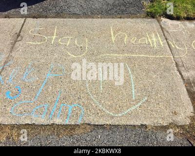 The words 'Keep Calm, Stay Healthy' written with sidewalk chalk in front of a home on April 01, 2020 in Toronto, Ontario, Canada. Canadians have been urged by officials to stay home in order to slow the spread of the novel coronavirus (COVID-19) outbreak across the country. The number of COVID-19 cases in the city of Toronto has risen by 500% of the past few weeks. The number of COVID-19 cases in Canada has risen to 9489 with 107 deaths. (Photo by Creative Touch Imaging Ltd./NurPhoto) Stock Photo