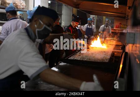 Chef palestinesi che indossano maschere protettive, preparano i pasti per le persone che sono state messe in quarantena, una precauzione contro la diffusione della malattia di coronavirus (COVID-19), in un ristorante nella città di Gaza, il 2 aprile 2020 (Foto di Majdi Fathi/NurPhoto) Foto Stock