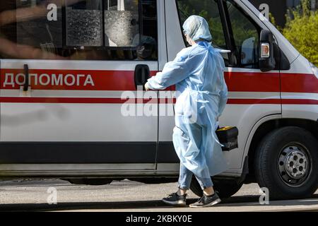 Ambulanza medico in tuta protettiva come misura contro il coronavirus COVID-19 vicino ambulanza auto in strada a Kyiv, Ucraina il 03 aprile 2020 (Foto di Maxym Marusenko/NurPhoto) Foto Stock