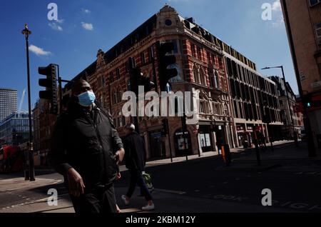 A man wearing a mask walks along a near-deserted Oxford Street in London, England, on April 4, 2020. Across the UK a total of 41,903 cases of the covid-19 coronavirus have so far been confirmed, with 4,313 people having died. The country meanwhile is now nearly a fortnight into its 'lockdown', which is set to be reviewed after an initial three-week period, although an extension is widely expected. Britain's Secretary of State for Health and Social Care Matt Hancock insisted yesterday that the government's continued insistence on people staying at home to avoid spreading the virus was 'not a re Stock Photo