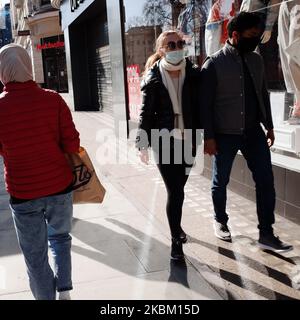 A couple wearing masks walk along a near-deserted Oxford Street in London, England, on April 4, 2020. Across the UK a total of 41,903 cases of the covid-19 coronavirus have so far been confirmed, with 4,313 people having died. The country meanwhile is now nearly a fortnight into its 'lockdown', which is set to be reviewed after an initial three-week period, although an extension is widely expected. Britain's Secretary of State for Health and Social Care Matt Hancock insisted yesterday that the government's continued insistence on people staying at home to avoid spreading the virus was 'not a r Stock Photo