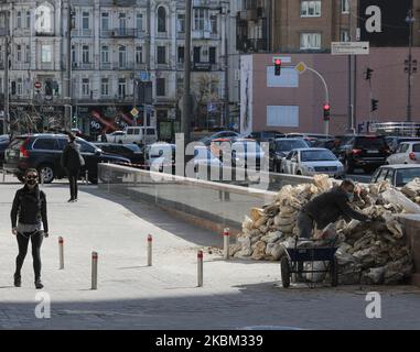 Persone con maschere a piedi e lavoro per strada a Kiev, Ucraina, 6 aprile 2020. Il governo ucraino ha rafforzato le misure restrittive di quarantena per prevenire la diffusione del COVID-19 in Ucraina dal 06 marzo. Le persone sono obbligate a indossare una maschera o un respiratore in tutti i luoghi pubblici, sono vietate le riunioni di un gruppo di più di due persone, nonché visitare parchi, giardini pubblici, aree ricreative, Ecc. i cittadini devono portare con sé documenti di identificazione per verificare se una persona debba essere in isolamento o in osservazione. (Foto di Sergii Kharchenko/NurPhoto) Foto Stock