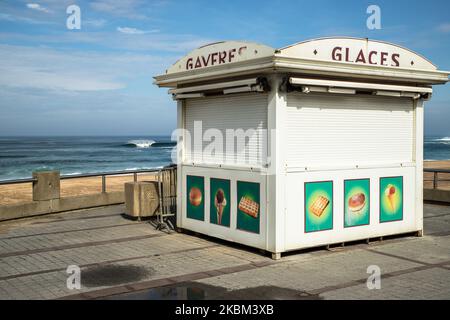 La vita quotidiana a Hossegor, sulla passeggiata sulla spiaggia rimane vuota, a Nouvelle Aquitaine, Francia, il 7 aprile 2020. Dopo 3 settimane di blocco in Francia, la gente rimane a casa, nessuno sulla spiaggia o nelle strade a Hossegor. Non ci sono turisti da Parigi o da altri sulla costa. Una donna in corsa, alcune persone sono a piedi, mentre il surf è vietato e le spiagge sono chiuse. Il mercato del pesce (la criee ), è ancora aperto a Capbreton, dove hanno luogo le norme di sicurezza. La polizia (gendarmerie francese) è presente per controllare le persone all'esterno. Hossegor di solito coronato durante questi passi vacanza è vuoto. (Foto di Jerome Gill Foto Stock