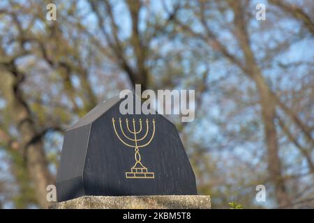 The menorah seen on tomb in an old jewish cemetery in Kazimierz, a historic Jewish quarter of Krakow. Passover, also known as 'Pesach, in Hebrew, is one of the most important festivals in the Jewish calendar and commemorates God liberating Jews from slavery in ancient Egypt This year Passover lasts from Wednesday 8 to Thursday 16 April, but celebrations will be unusually muted due to the coronavirus pandemic. On Wednesday, April 8, 2020, in Krakow, Poland. (Photo by Artur Widak/NurPhoto) Stock Photo