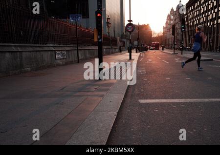 Una donna scherza attraverso una strada quasi deserta di Bridge Street fuori delle Houses of Parliament al tramonto a Londra, Inghilterra, il 8 aprile 2020. Con il paese che non prevede di raggiungere il suo 'picco' di coronavirus covid-19 per un'altra settimana o più, le attuali condizioni di blocco in vigore in tutto il Regno Unito sono ampiamente previste per essere estese nei prossimi giorni oltre la fine imminente, lunedì prossimo, del periodo di tre settimane di restrizioni inizialmente imposto. Si dice che il Segretario degli esteri Dominic Raab affronti la questione alla conferenza stampa quotidiana di giovedì. Raab è attualmente in sostituzione di prime Foto Stock