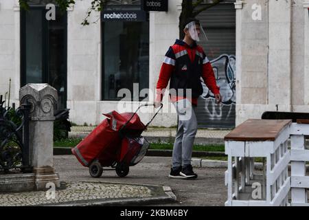 Un postino in tuta protettiva cammina vicino al parco Don Luis i a Lisbona il 8th aprile 2020. Dopo l'istituzione dello stato di emergenza in Portogallo, il 18 marzo 2020, durante il quale alcune libertà individuali sono state sospese nel tentativo di mitigare le azioni del virus COVID-19, il numero di malati continua ad aumentare, con 13.141 infetti e 380 deceduti. (Foto di Jorge Mantilla/NurPhoto) Foto Stock