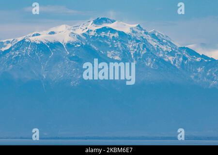 Monte Olimpo innevato come si vede dalla città di Salonicco in Grecia dopo il raro tempo e la nevicata di aprile, la montagna è dietro il mare, il golfo di Thermaikos. Il Monte Olimpo è la montagna più alta della Grecia, con un'altitudine della vetta più alta, Mytikas a 2918m m. Mt. Olimpo fu la casa degli dei greci secondo l'antica mitologia greca. Oggi la montagna è nota per la ricca biodiversità, la ricca flora ed è un Parco Nazionale, il primo in Grecia dal 1938. La montagna è una destinazione estiva ed invernale molto apprezzata per le escursioni, il trekking, l'arrampicata ma anche per i turisti in quanto sono ricchi di f Foto Stock